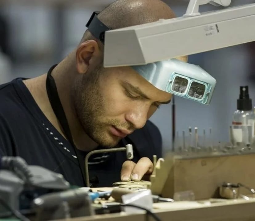 A jeweller examining work under magnification at the bench, the way diamond clarity is judged